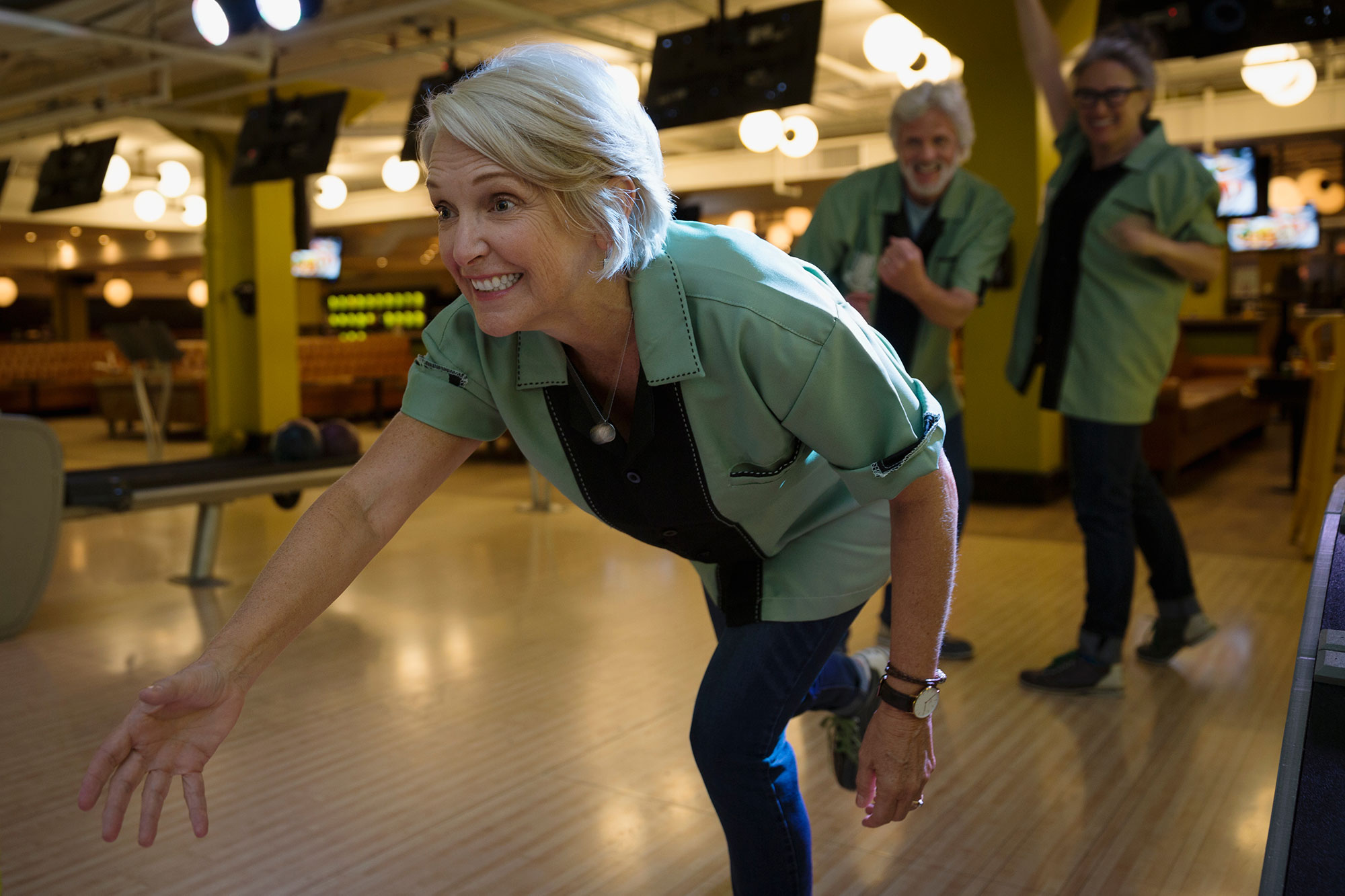 woman bowling with a team at the bowling alley